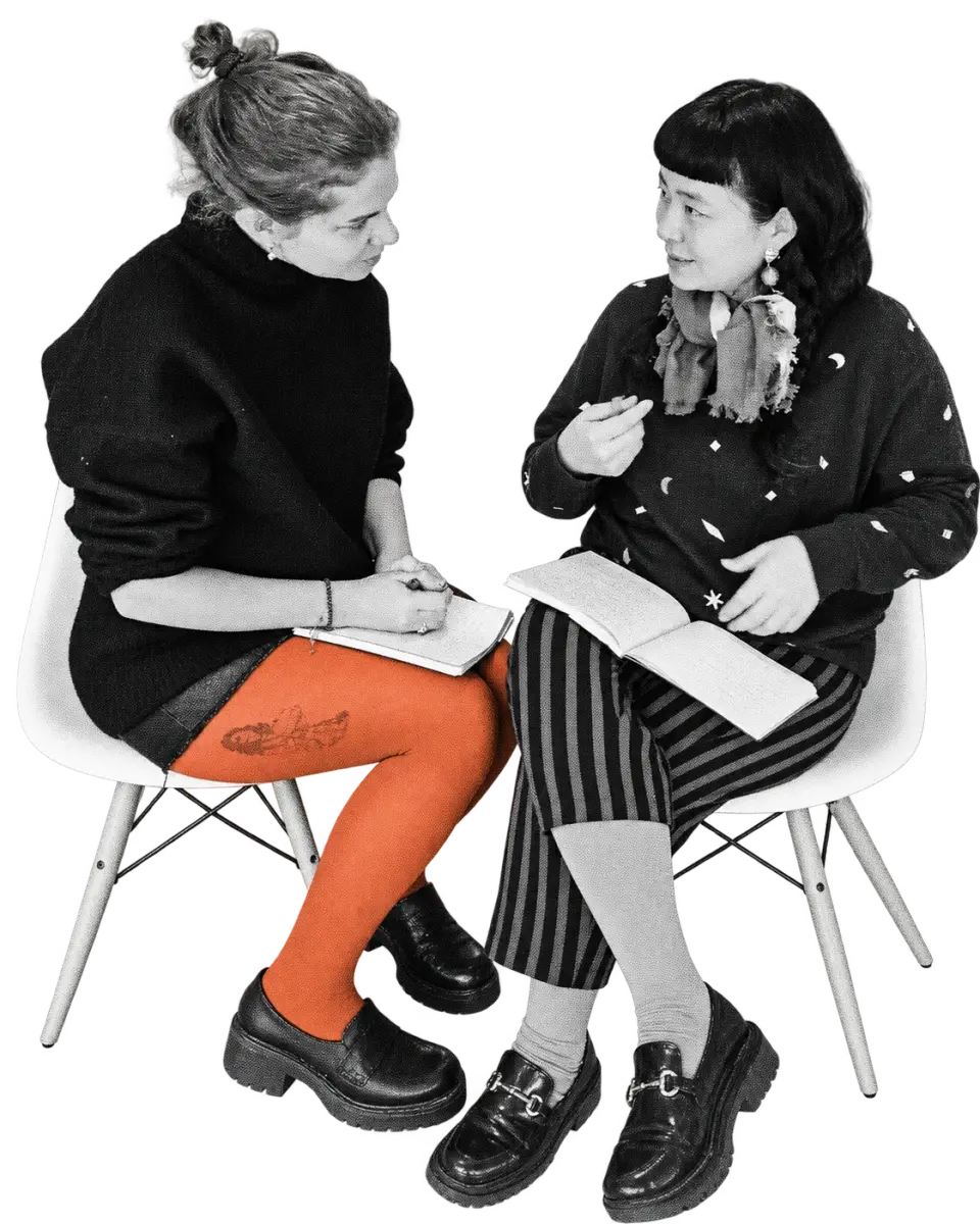 Two Languages of the Heart participants sharing reflections with open notebooks, in photographic halftone