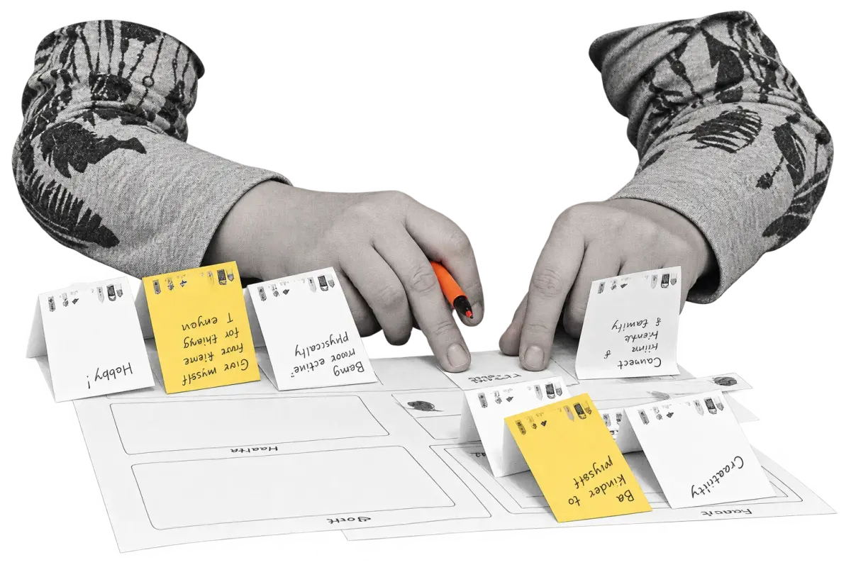 Hands arranging handwritten reflection notes during a Mental Bytes retreat